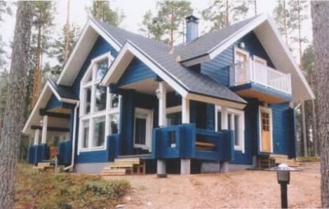 Sininen hirsiomakotitalo mäntymetsän keskellä